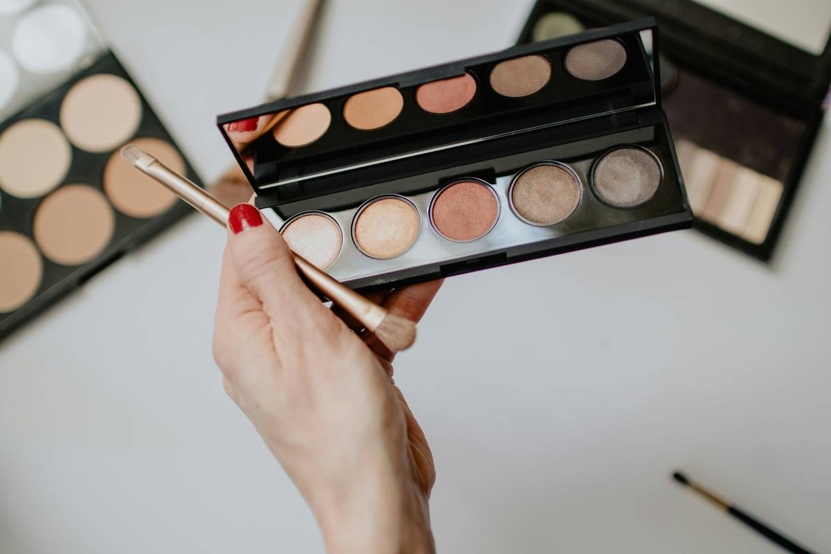 Close-up of a lip makeup brush applying red liquid lipstick with precise control along the cupid's bow